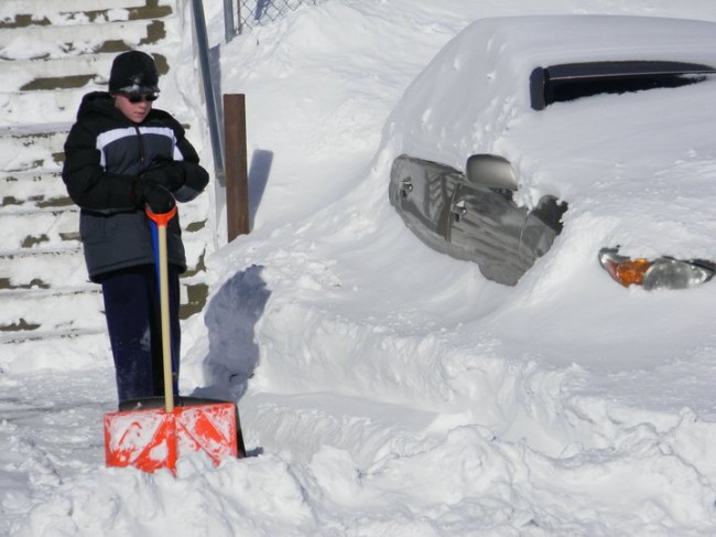 My son (taken a couple of years ago) getting ready to help an elderly neighbor shovel out his car. 