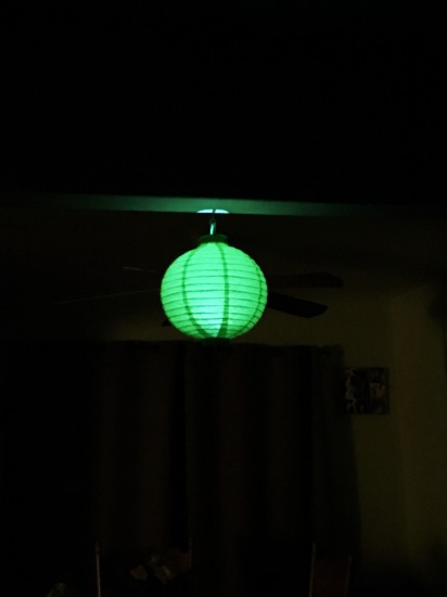 The blades from the nearby ceiling fan can be seen behind the lantern. They are not a part of it.